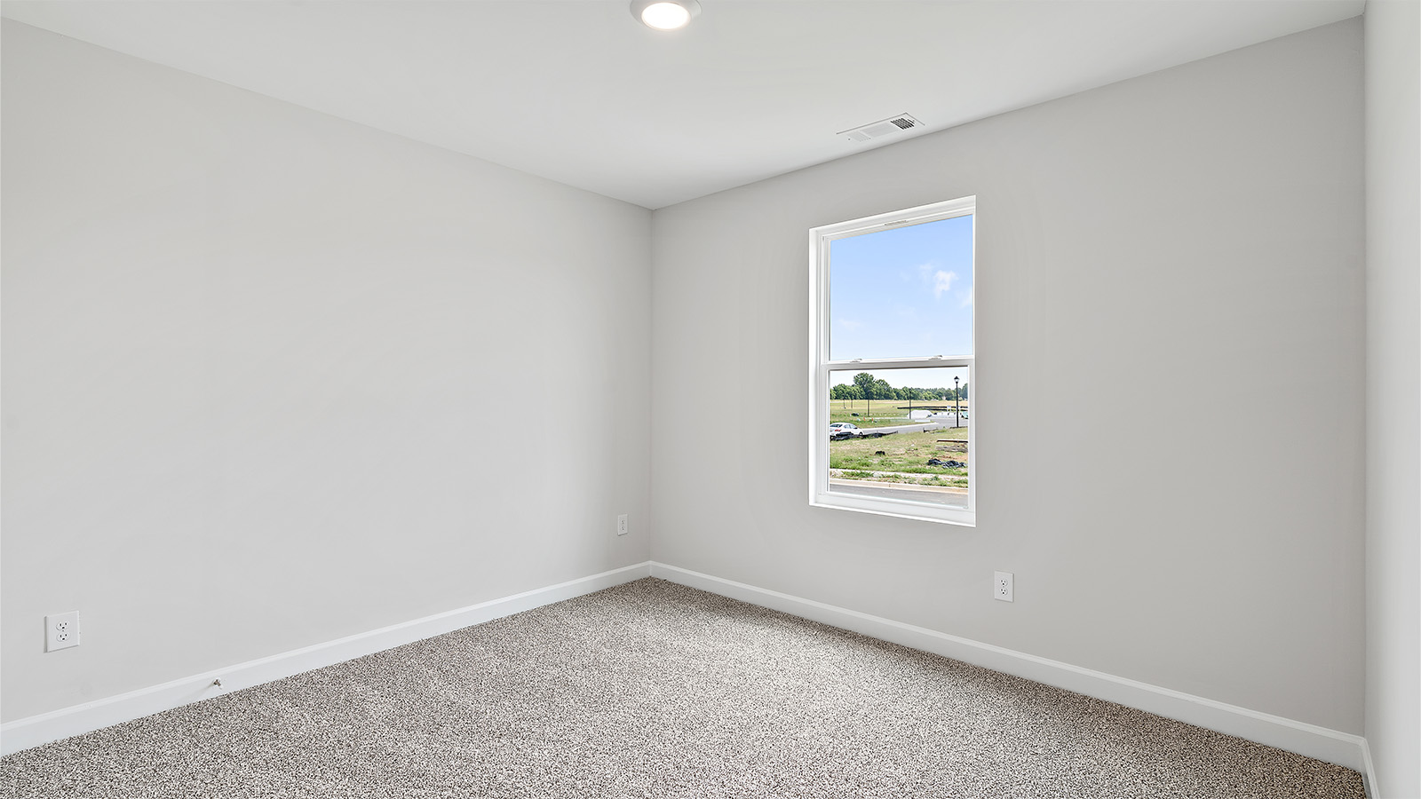 Comfortable guest bedroom with natural light and storage