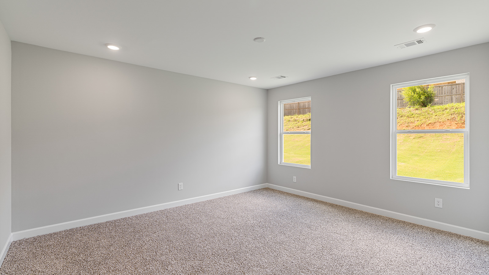 Primary bedroom featuring plush carpet and abundant natural light