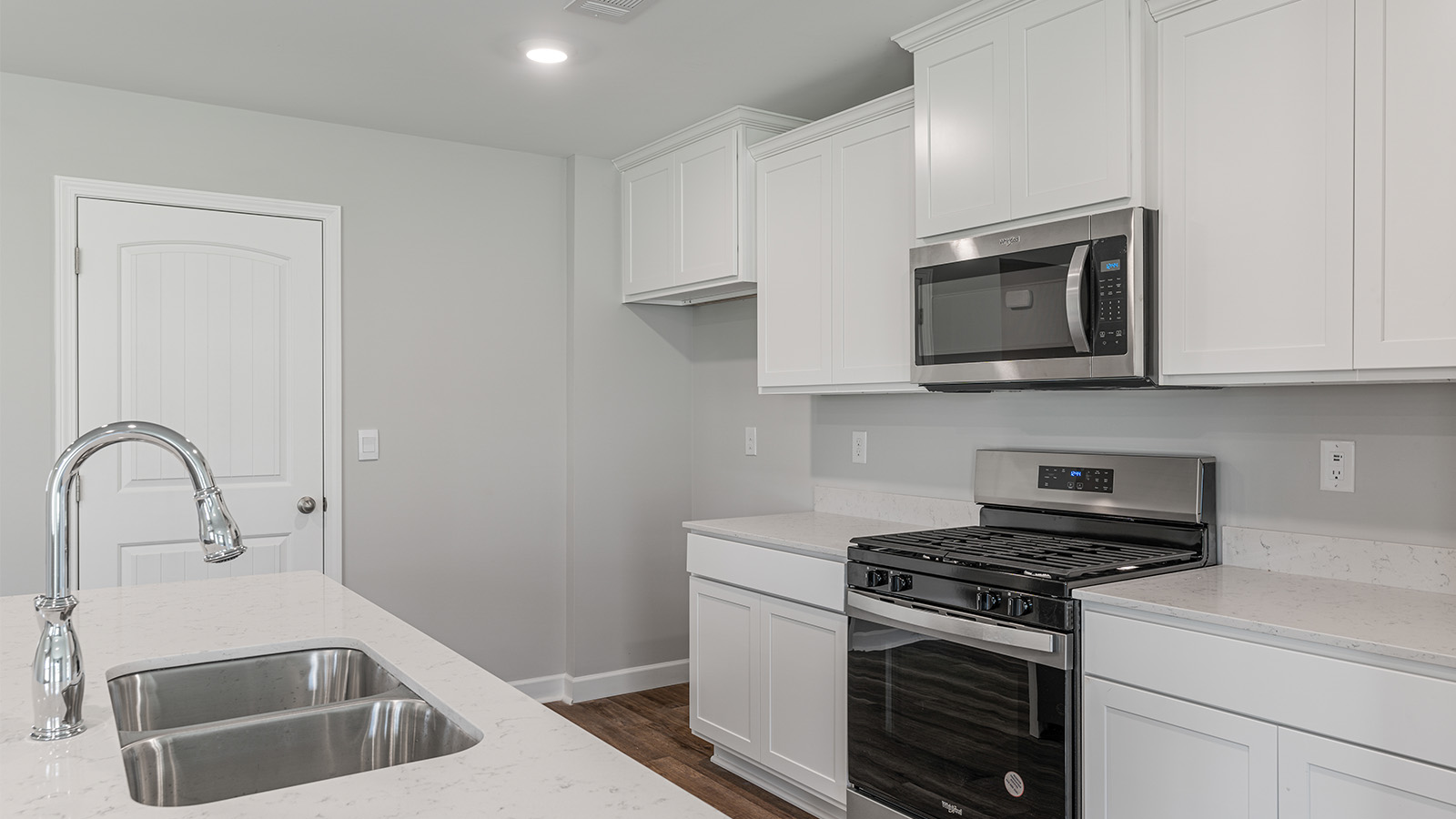 luxury vinyl plank flooring in kitchen with stainless steel appliances and Quartz countertops with soft close cabinets