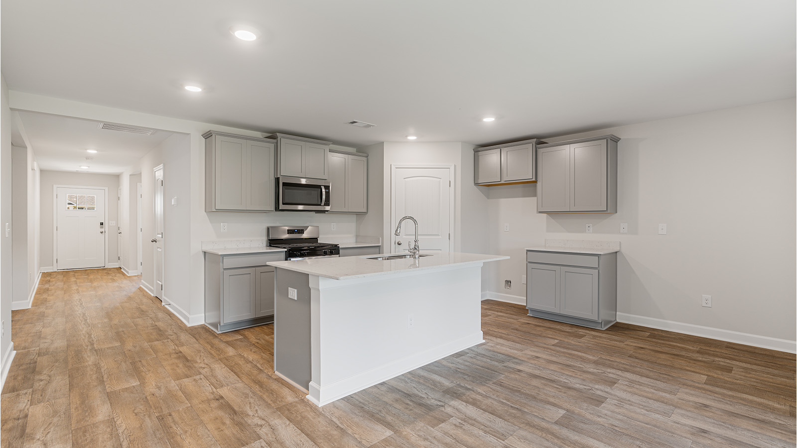 luxury vinyl plank flooring in kitchen with stainless steel appliances and Quartz countertops with soft close cabinets