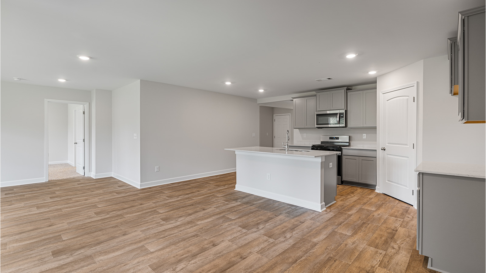 luxury vinyl plank flooring in kitchen with stainless steel appliances and Quartz countertops with soft close cabinets