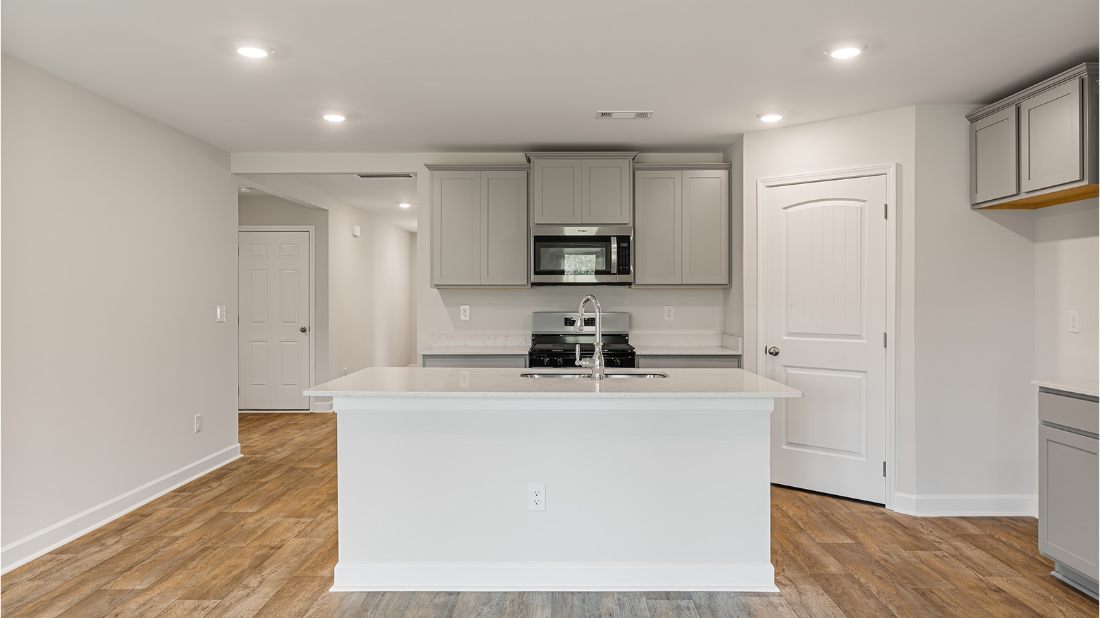 luxury vinyl plank flooring in kitchen with stainless steel appliances and Quartz countertops with soft close cabinets