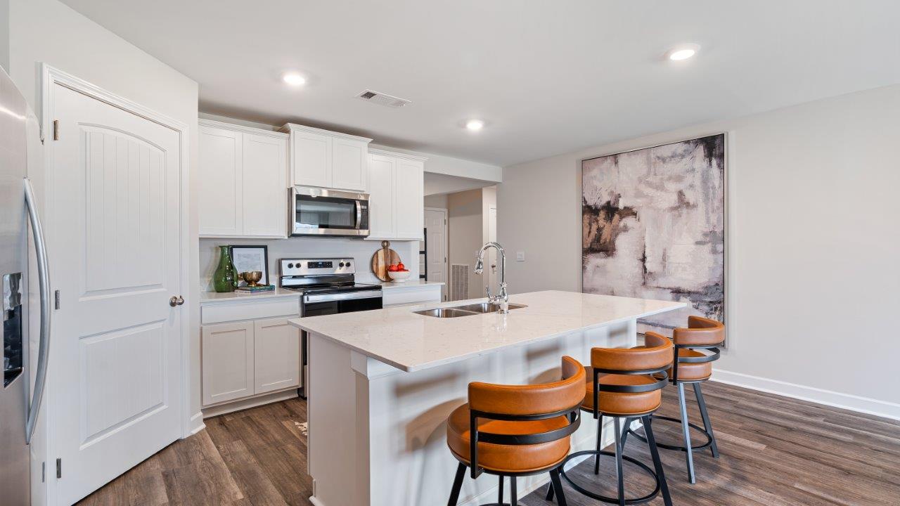 Open concept living room with LVP flooring and seamless flow to the kitchen and dining area.