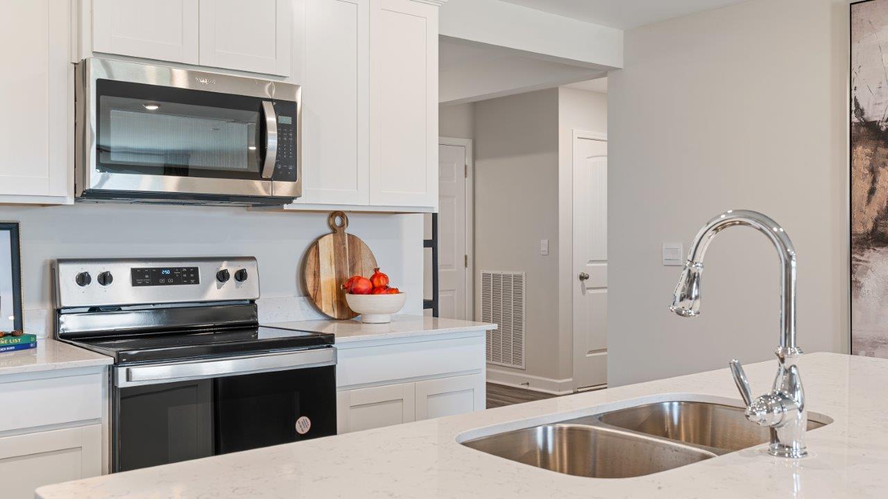 Open concept living room with LVP flooring and seamless flow to the kitchen and dining area.