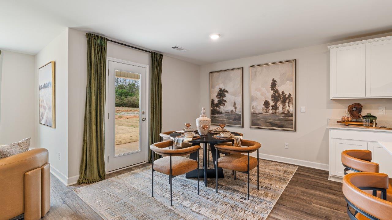Open concept living room with LVP flooring and seamless flow to the kitchen and dining area.