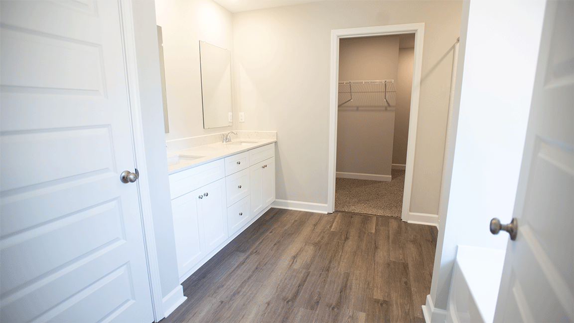 Bright primary bathroom with quartz countertops, a garden tub, and a standalone shower