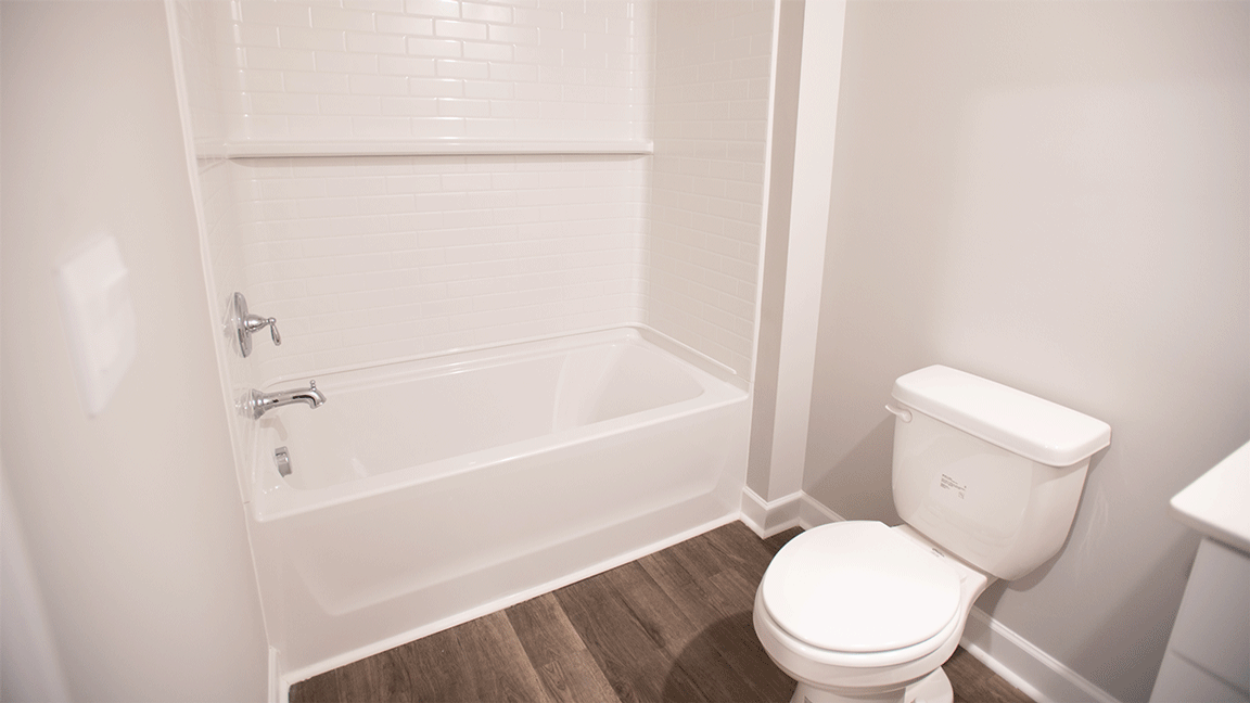 Guest ready bathroom with a practical tub/shower combo and neutral finishes.