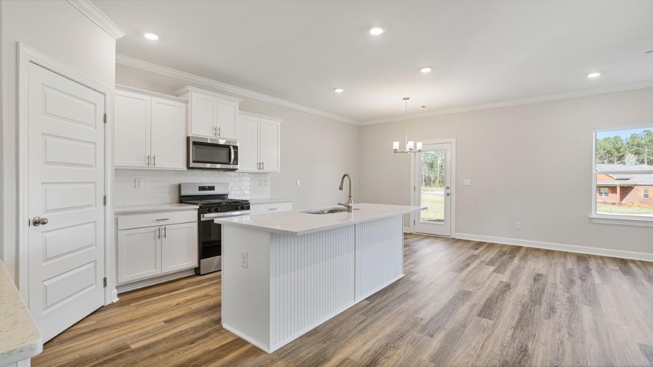 The Carol floorplan interior with quartz countertops, LVP flooring, and open layout.