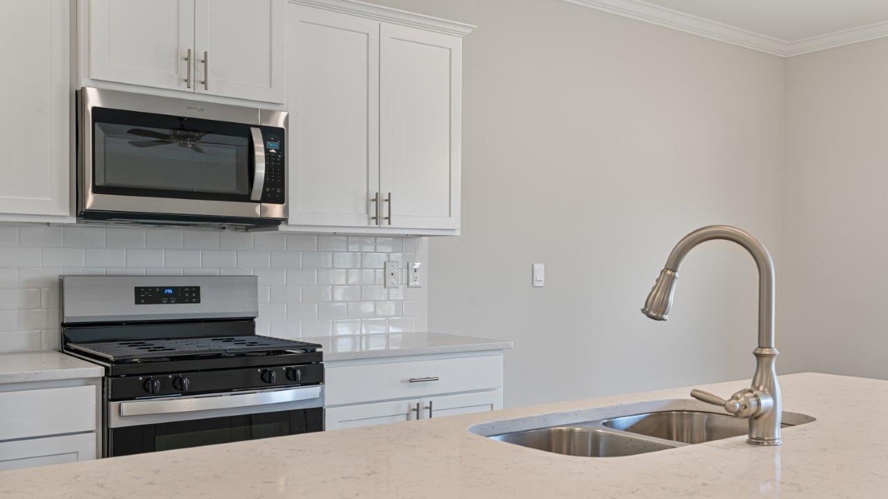 The Carol floorplan interior with quartz countertops, LVP flooring, and open layout.