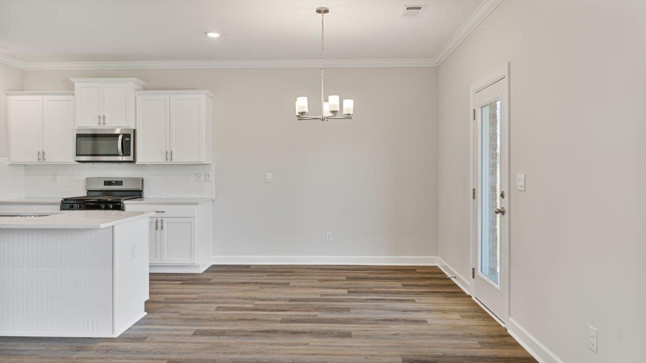 The Carol floorplan interior with quartz countertops, LVP flooring, and open layout.