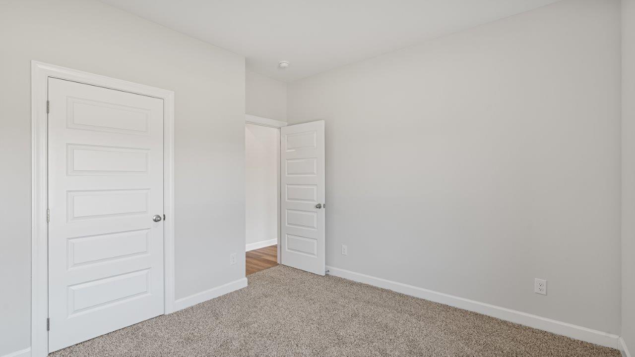 The Carol floorplan interior with quartz countertops, LVP flooring, and open layout.