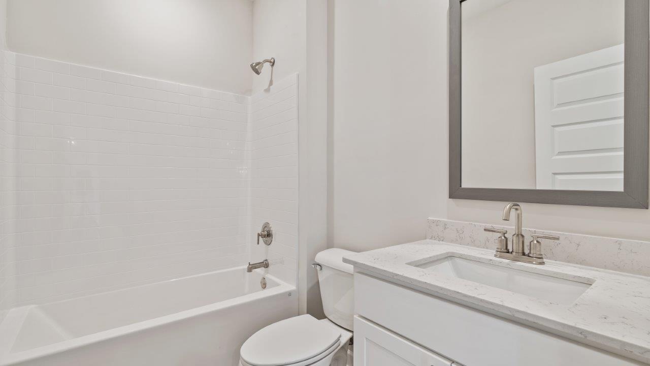 The Carol floorplan interior with quartz countertops, LVP flooring, and open layout.