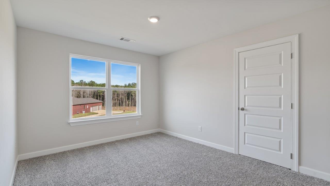 The Carol floorplan interior with quartz countertops, LVP flooring, and open layout.
