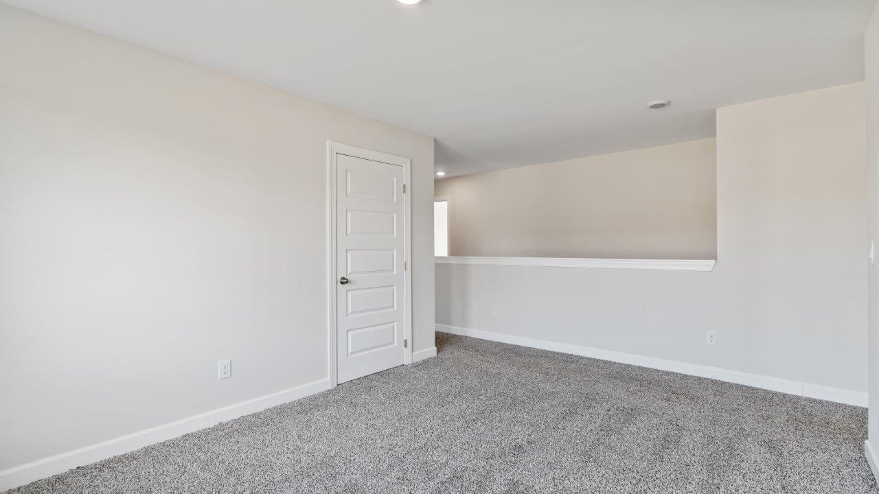 The Carol floorplan interior with quartz countertops, LVP flooring, and open layout.