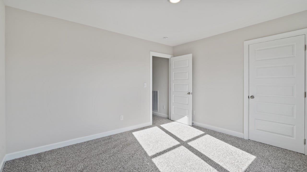 The Carol floorplan interior with quartz countertops, LVP flooring, and open layout.