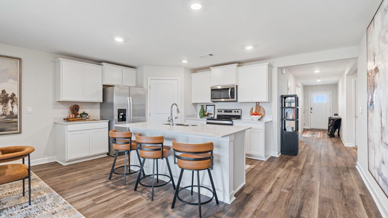 luxury vinyl plank flooring in kitchen with stainless steel appliances and Quartz countertops with soft close cabinets