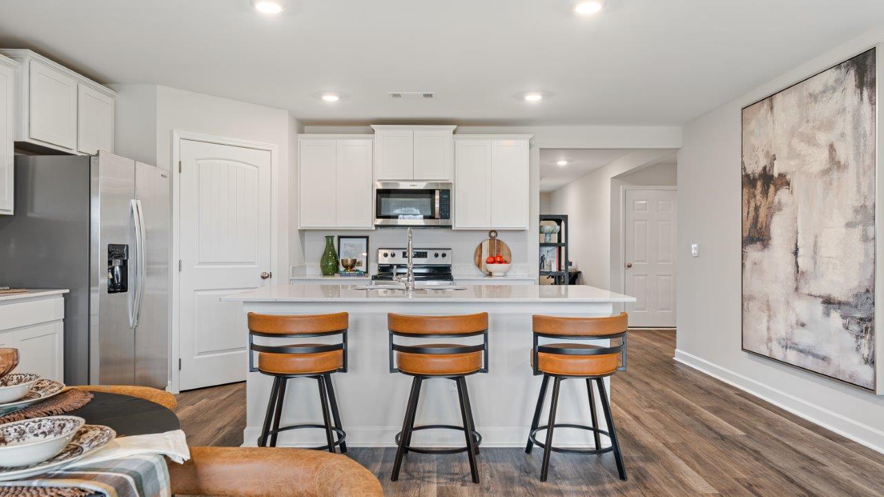 luxury vinyl plank flooring in kitchen with stainless steel appliances and Quartz countertops with soft close cabinets
