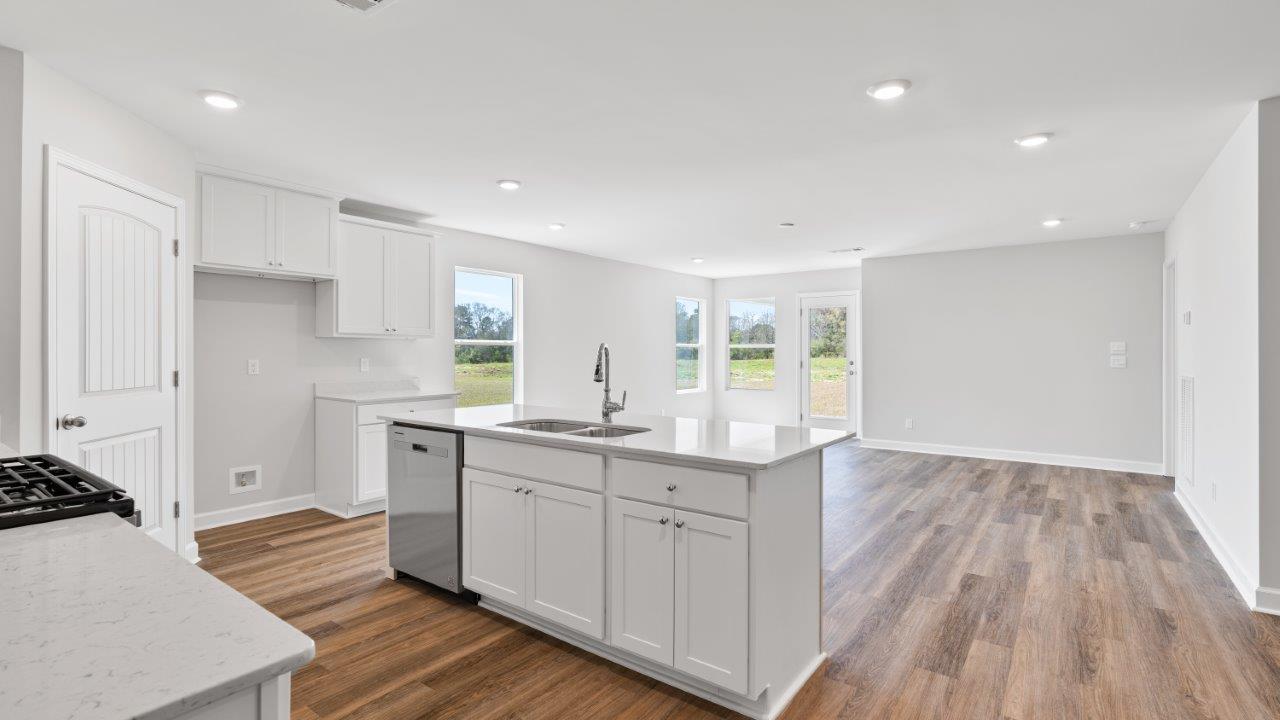 luxury vinyl plank flooring in kitchen with stainless steel appliances and Quartz countertops with soft close cabinets
