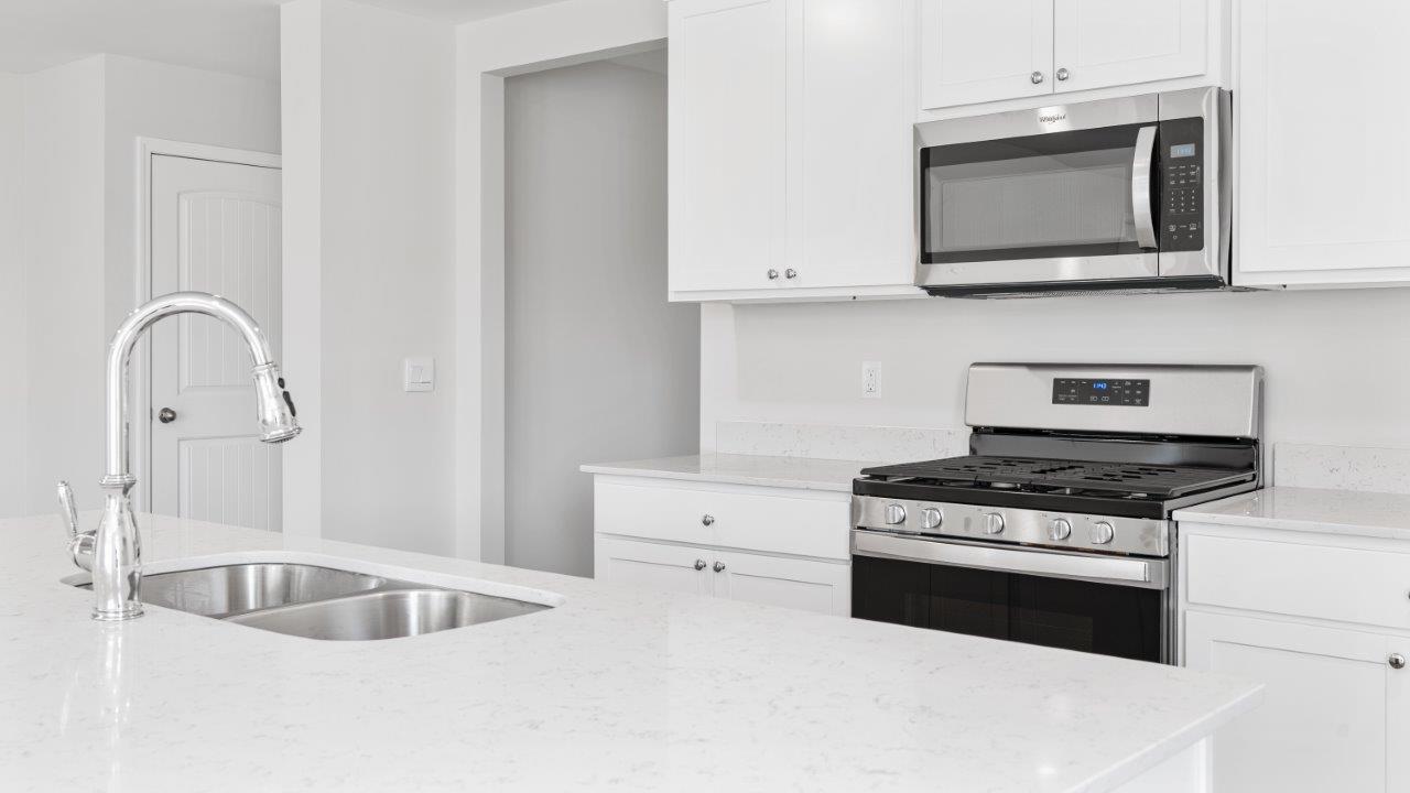 luxury vinyl plank flooring in kitchen with stainless steel appliances and Quartz countertops with soft close cabinets