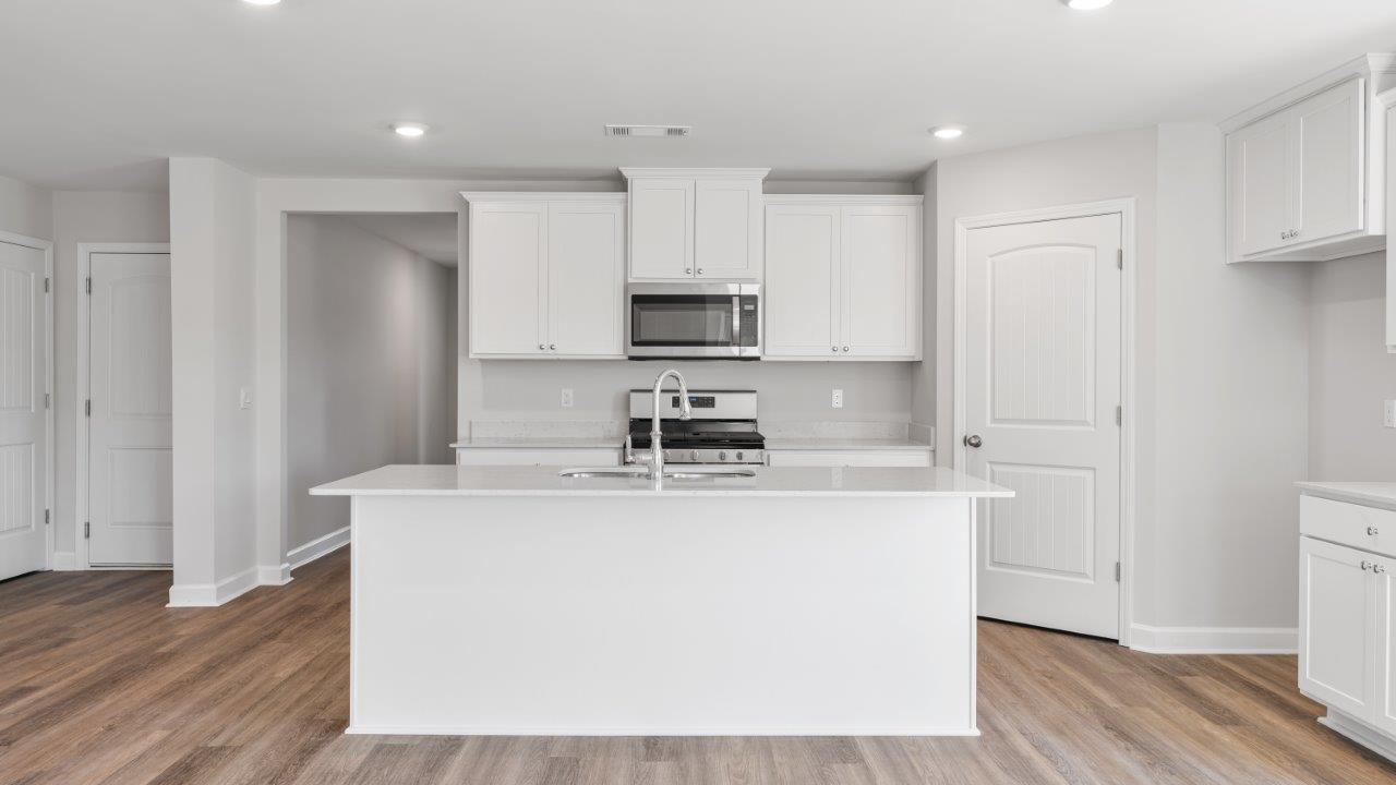 luxury vinyl plank flooring in kitchen with stainless steel appliances and Quartz countertops with soft close cabinets