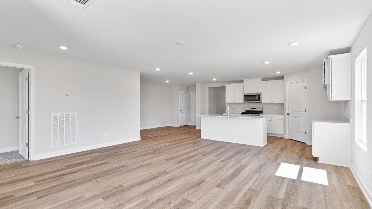 luxury vinyl plank flooring in kitchen with stainless steel appliances and Quartz countertops with soft close cabinets