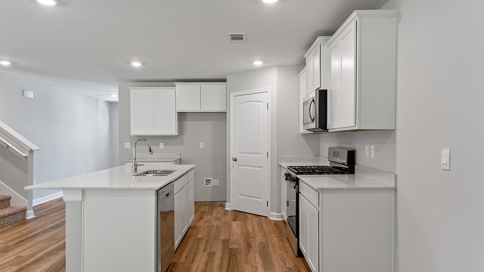 luxury vinyl plank flooring in kitchen with stainless steel appliances and Quartz countertops with soft close cabinets