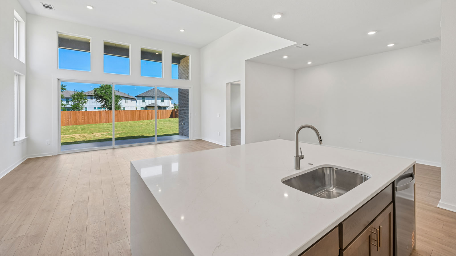Large kitchen island with beautiful view of sliding glass doors and backyard.