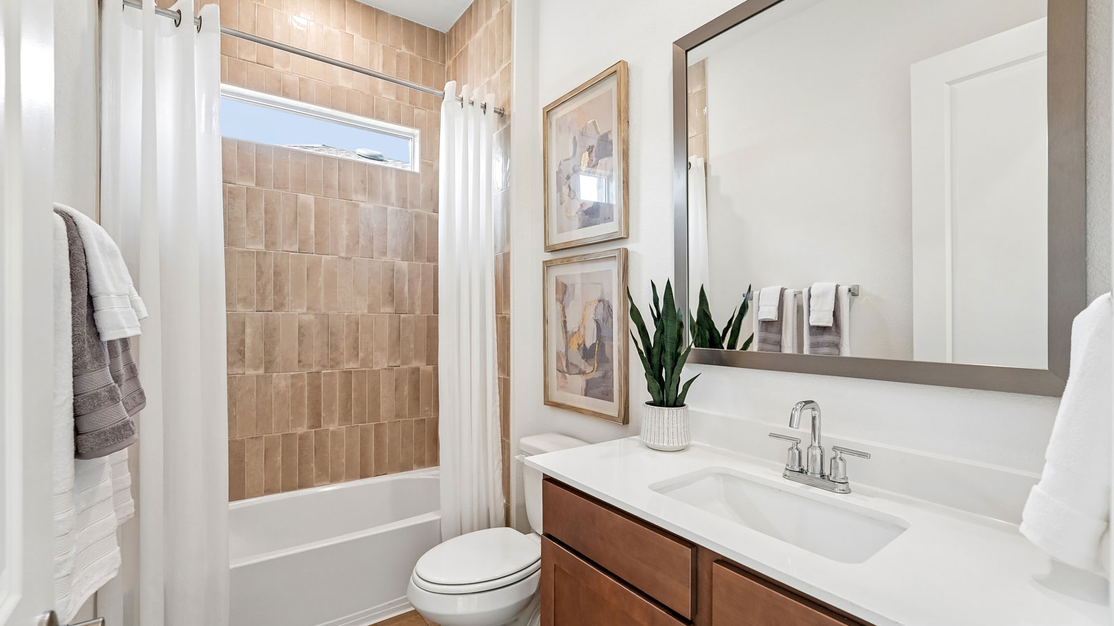 Bathroom 2 with tub, raised shower head, and window.