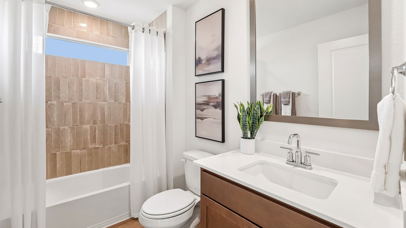 Secondary bathroom with bathtub, raised shower head, and window.