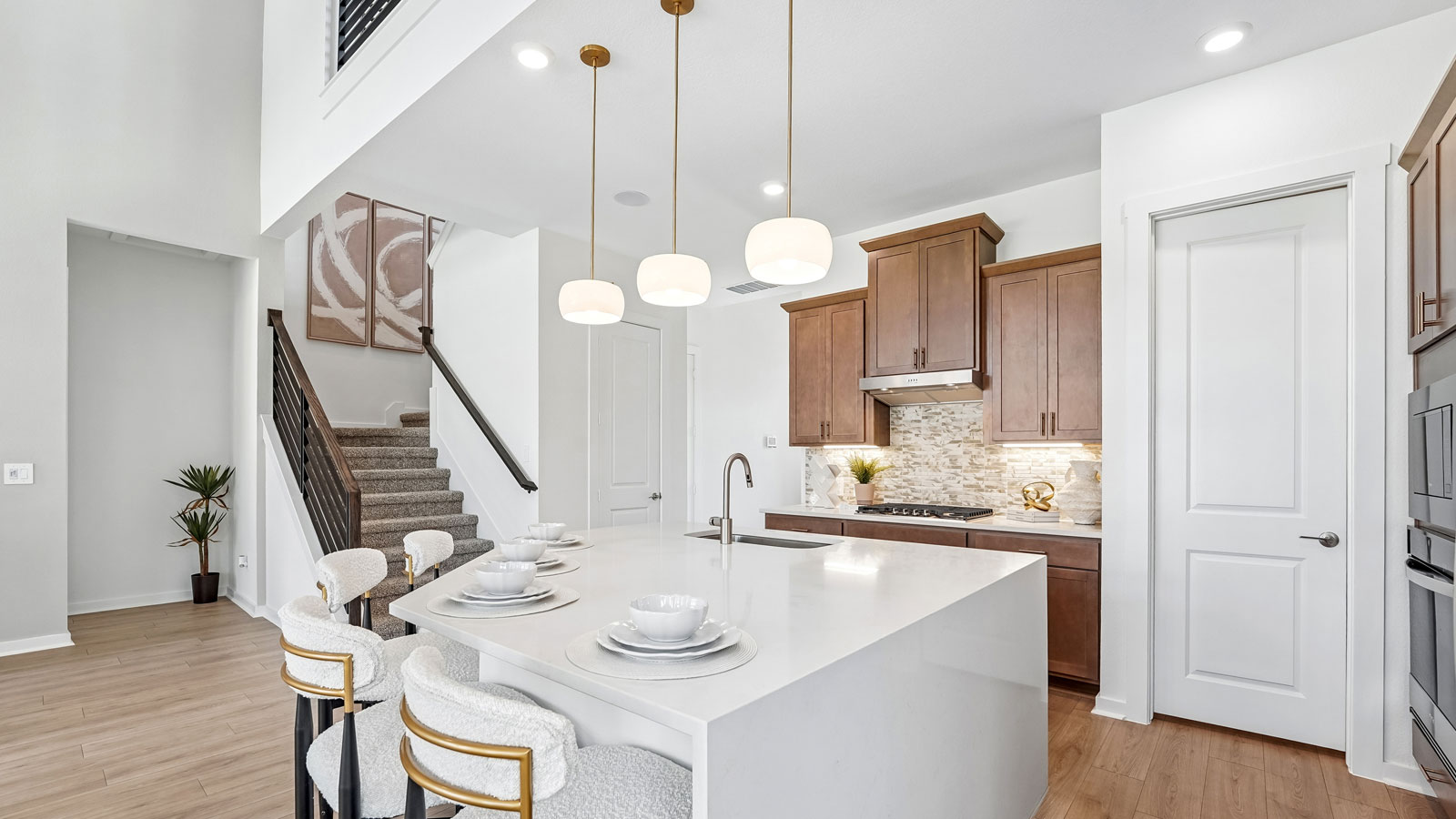 Luxurious kitchen with waterfall island and elegant pendant lights.