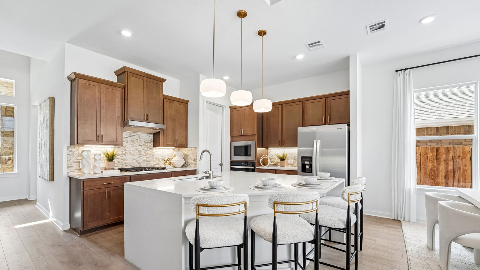 Luxurious kitchen with waterfall island and elegant pendant lights.