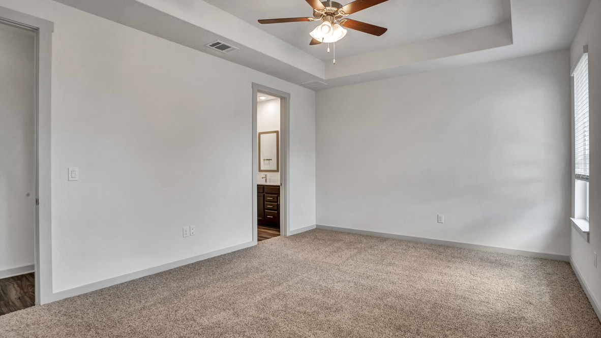 Bedroom with brown carpet, white walls, and a window.