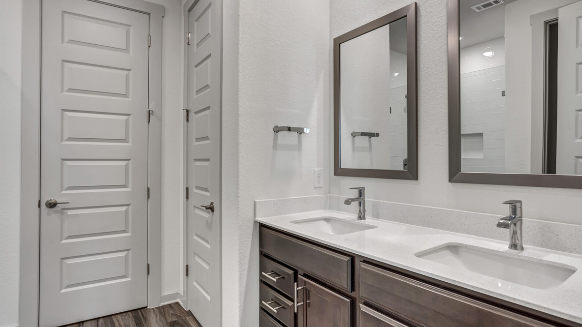 Bathroom with dual sinks with two mirrors above.