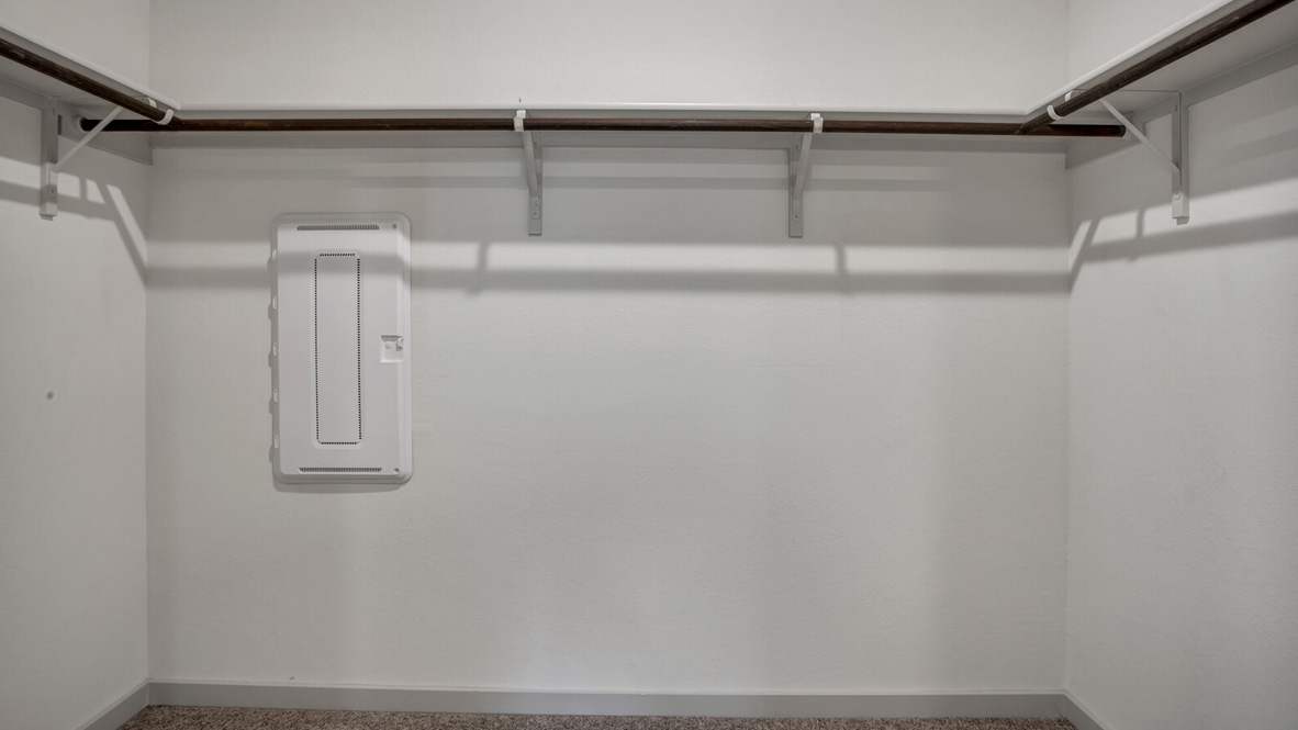 Walk in closet with hanging rod.