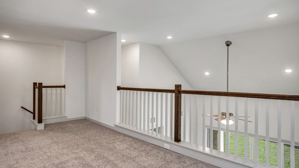 Landing at the top of stairs with a wooden railing.