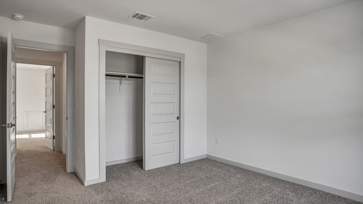 Bedroom with brown carpet, white walls, and a closet.