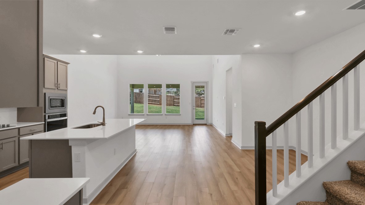 Spacious great room with view into kitchen and staircase leading to upper level in Thunder Rock