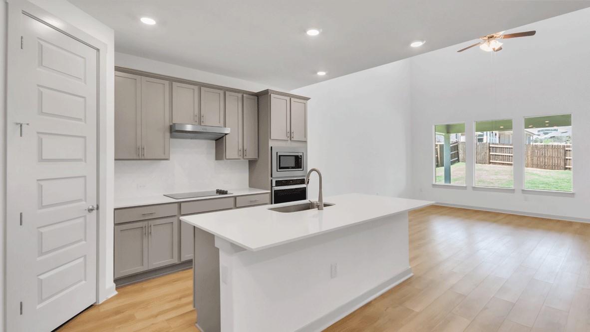 Great room with tile flooring and view of kitchen island and built-in stainless steel oven at Thunder Rock