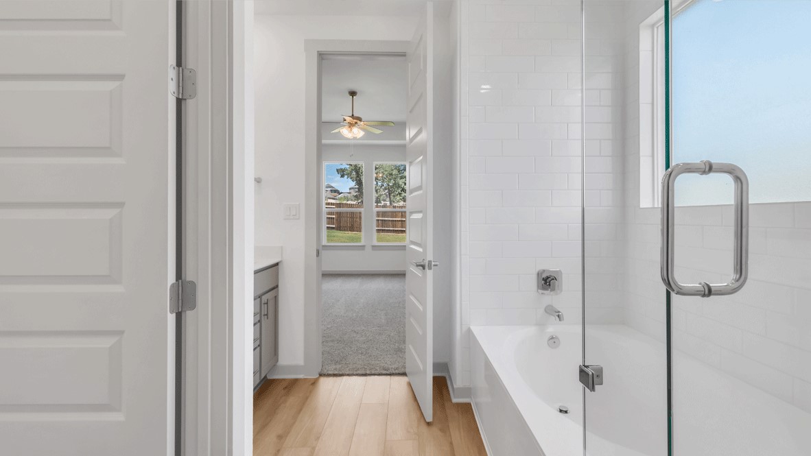 Family bath with modern cabinetry, chrome faucet, and quartz counter at Thunder Rock by D.R. Horton