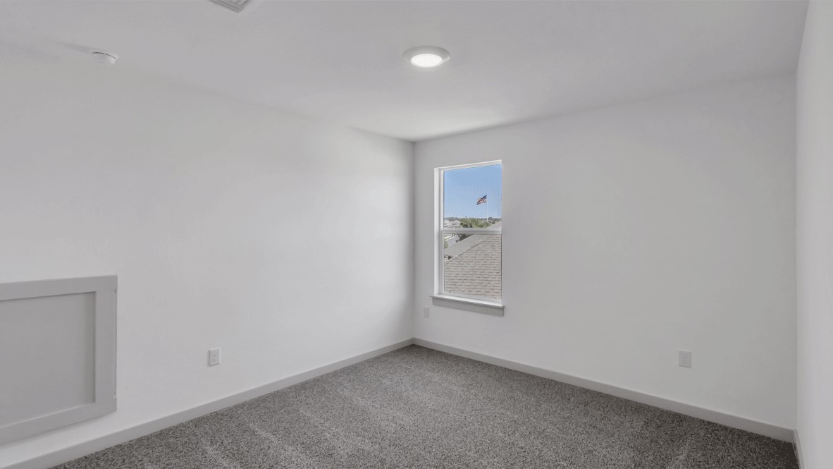 Primary bedroom in this D.R. Horton New Home features tray ceiling, double windows, and soft carpet underfoot.