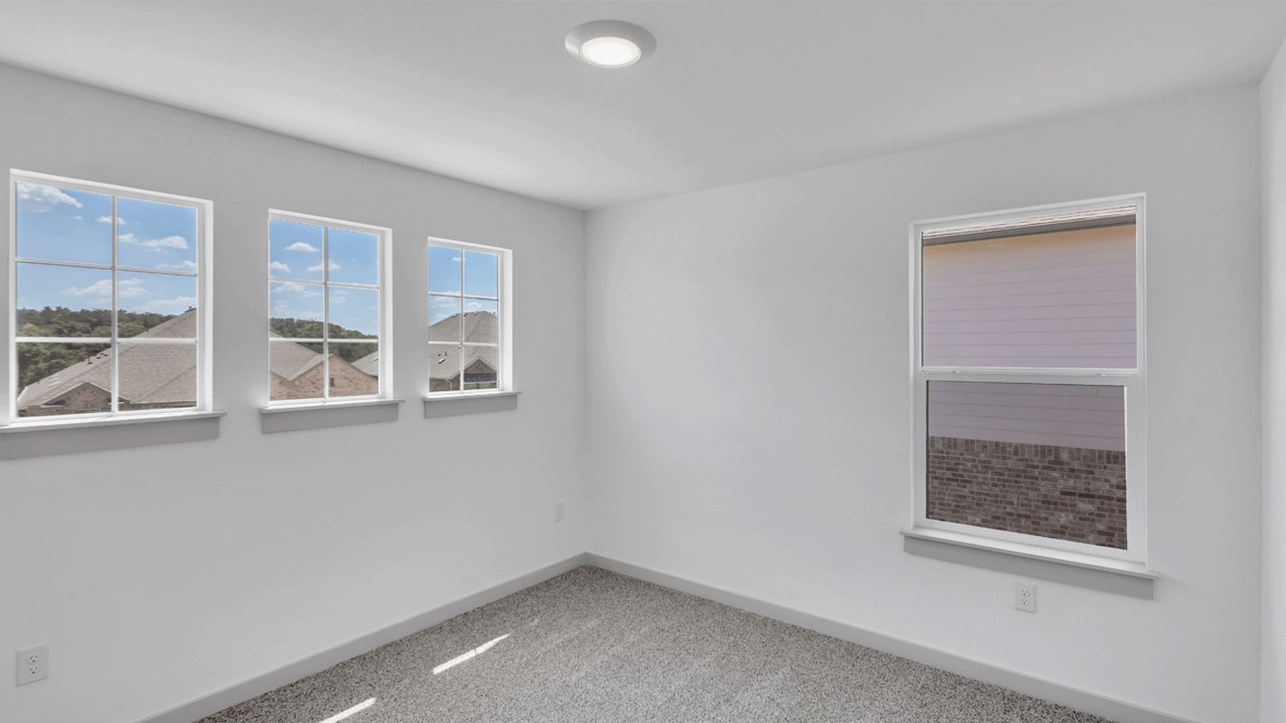 Bright and open primary bedroom in Thunder Rock with neutral paint and large window overlooking backyard.