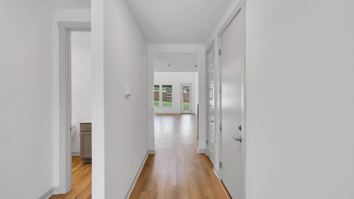Foyer and entry hall combination in this New Homebuilder layout features durable flooring, high ceilings, and direct line of sight to rear windows and patio door