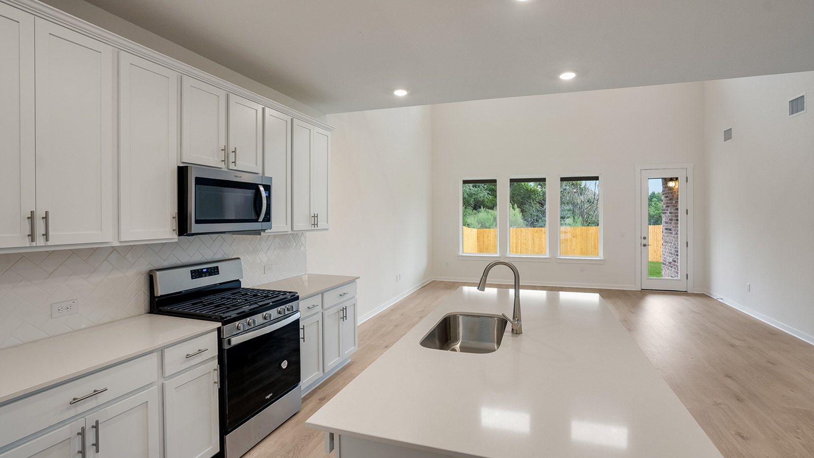 Kitchen with silestone countertops, stainless steel appliances, and decorative backsplash.