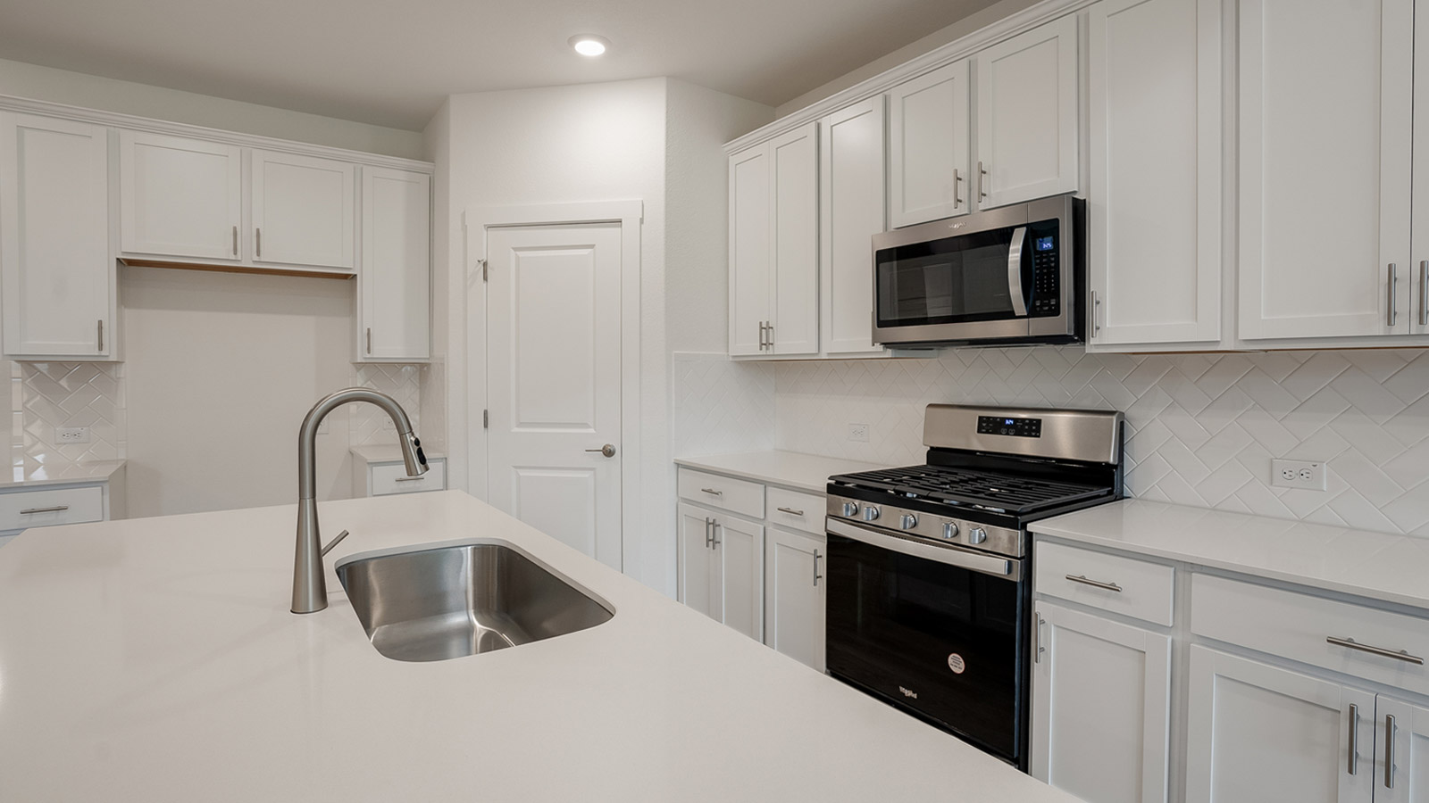 Kitchen with silestone countertops, stainless steel appliances, and decorative backsplash.