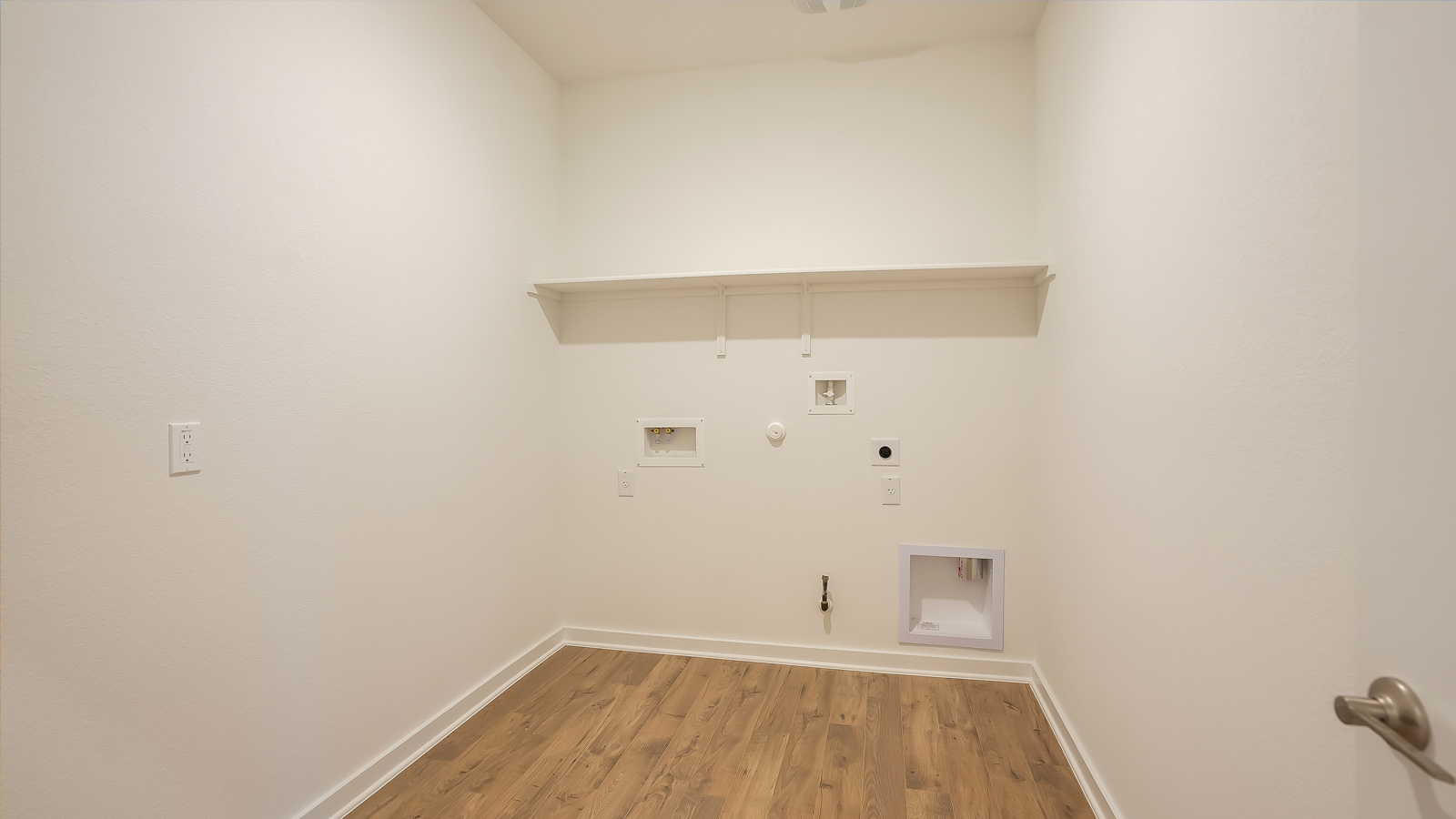 Utility laundry room featuring washer and dryer included with overhead storage and clean finishes Rosenbusch Ranch