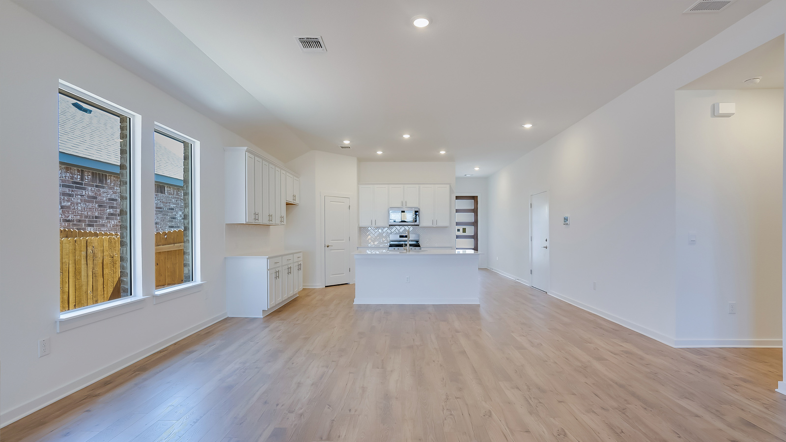 Open living room with laminated wood flooring.