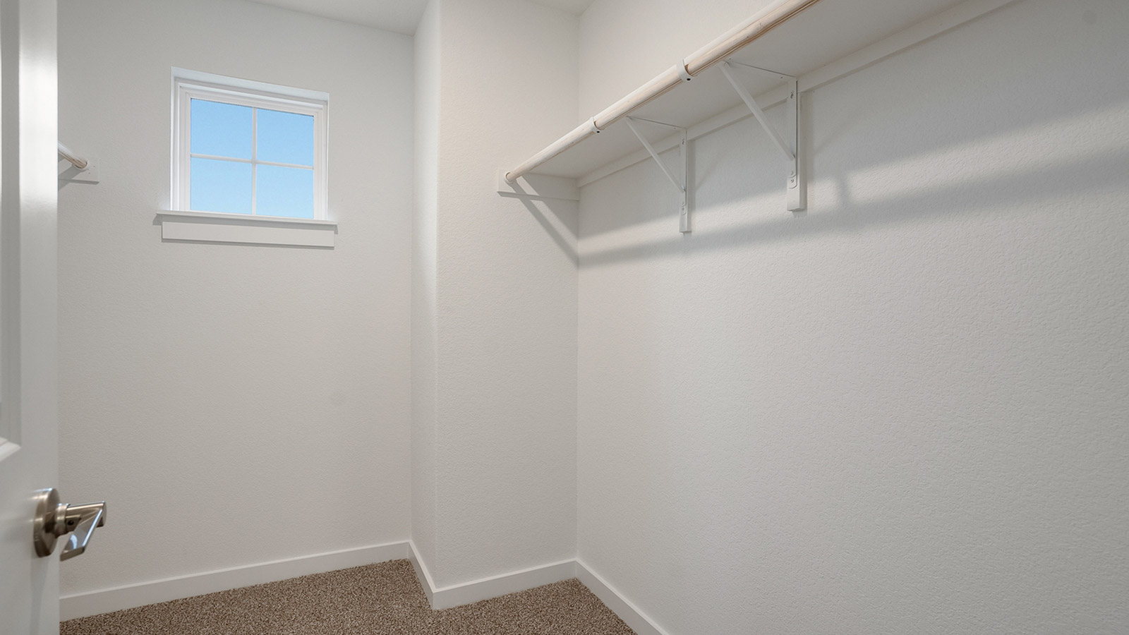 Interior view of walk-in closet in the primary bedroom and spa-inspired ensuite in Rosenbusch Ranch  new home by D.R. Horton