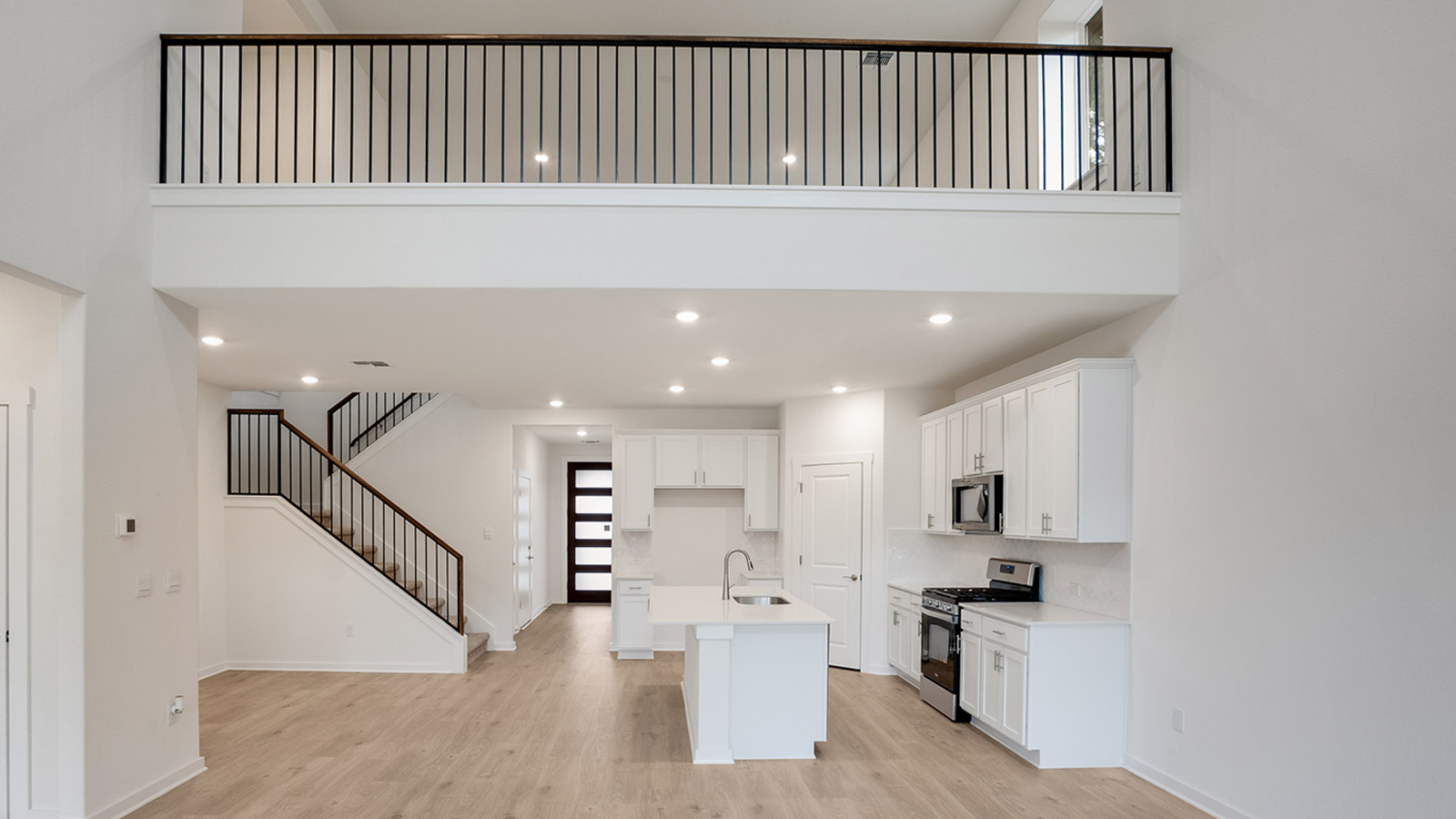 Kitchen, dining, family room blend together with ease of access to backyard view, upstairs access in D.R. Horton new home