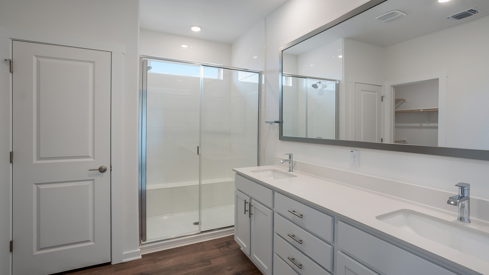 Luxurious main bathroom with double vanity sink and walk-in shower.