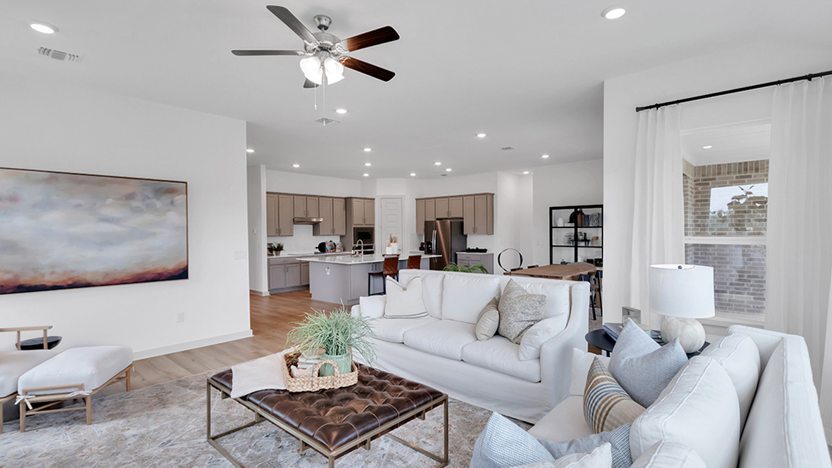 Spacious living room with large windows and natural front light, near the main area in this new build home